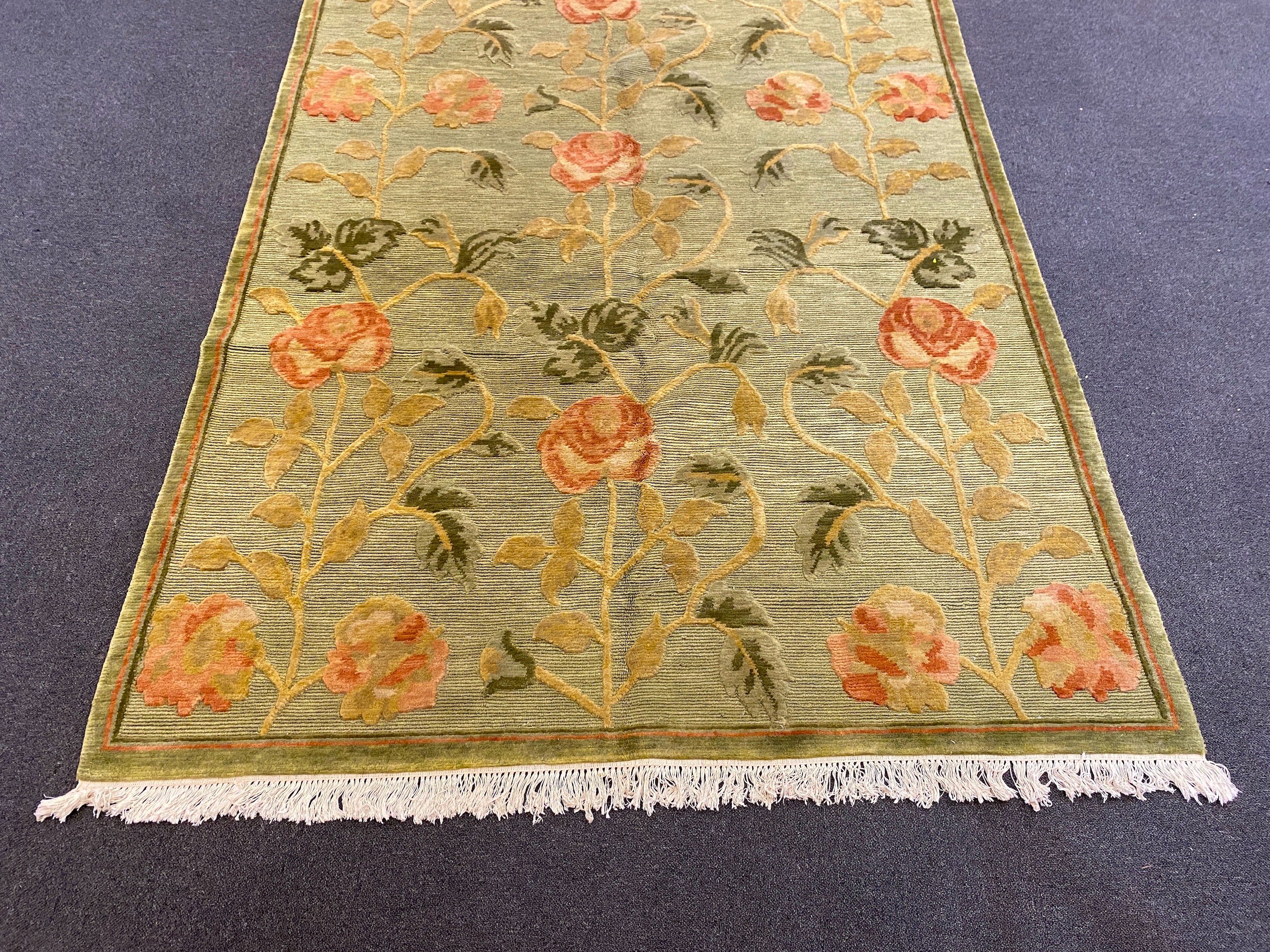 A Tibetan pale green ground carpet, 250cm x 176cm